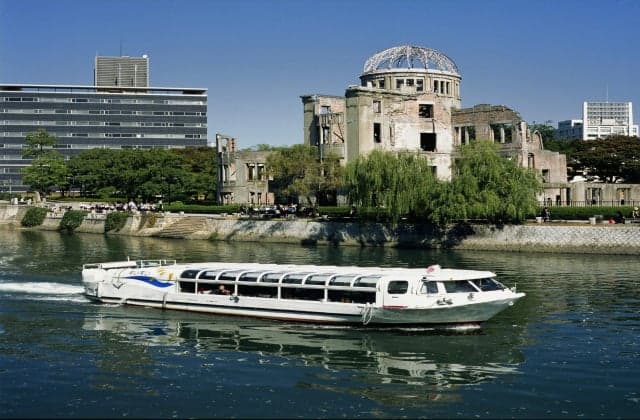 The Hiroshima Peace Memorial Museum and a pleasure boat running on the river