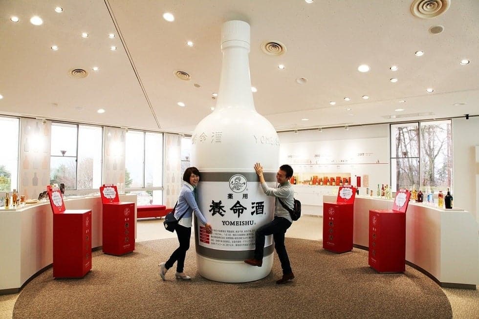A popular photo spot in front of the large Yomeishu bottle in the tour facility!